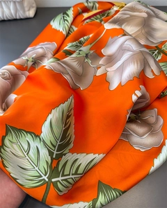 Detail of silk satin scarf with floral rose print and smooth glossy fabric texture