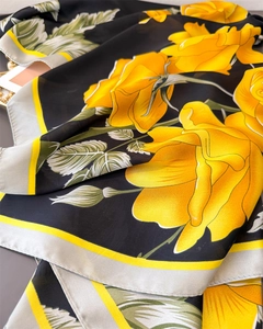 Detail of yellow rose print on black satin scarf with smooth silk-like texture