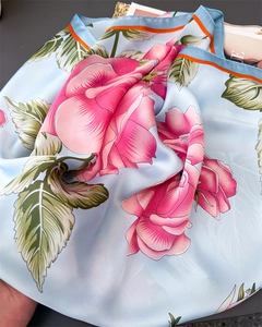 Macro detail of floral satin silk scarf showing intricate print and smooth fabric texture