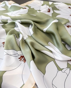 Detailed macro view of the silky satin texture and elegant white magnolia floral print