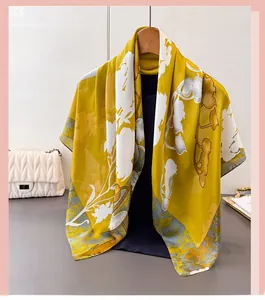 Gros plan d'un foulard en satin jaune gingembre avec motifs floraux sur un cintre en bois
