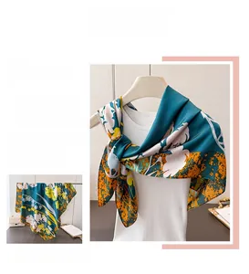 Détail d'un élégant foulard en satin avec imprimé floral abstrait en vert et orange
