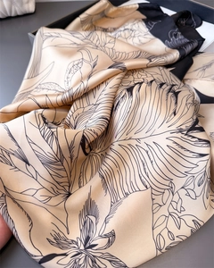 Close-up of floral satin scarf showing detailed sketch leaf pattern and silky texture