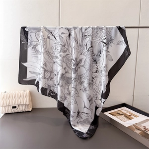 Artistic black and white floral sketch satin square scarf draped on a metal hanger