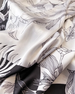 Macro shot of satin silk scarf showing artistic floral print and smooth fabric texture