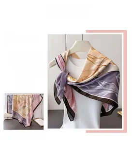 Dettaglio di sciarpa in raso di seta con eleganti motivi botanici e design color block