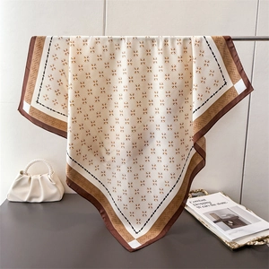 Eleganter beige-brauner Seidenschal mit geometrischem Blumenmuster am Kleiderbügel