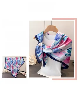Detailed view of satin floral scarf with blue and pink abstract prints and navy border