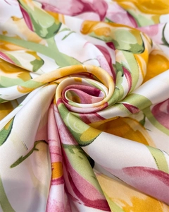Macro shot of abstract floral print satin scarf showing silky texture and vibrant colors