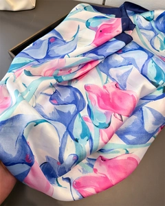 Macro detail of satin silk scarf with abstract floral pattern and rolled edge