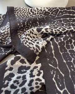 Detail shot of the diagonal twill texture and leopard print pattern on a soft scarf