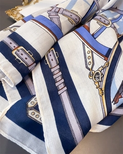 Detailed close-up of retro equestrian belt pattern on a vintage silk feeling scarf