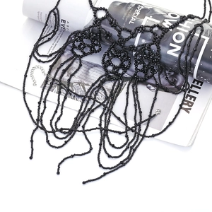 Macro shot of multi-layer black beaded body chain with intricate tassel fringe detailing