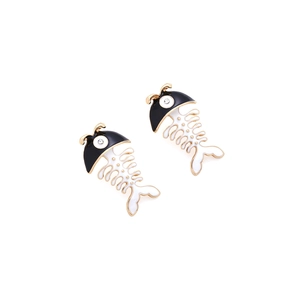 Detail view of fishbone enamel earrings featuring black and white segments with gold trim