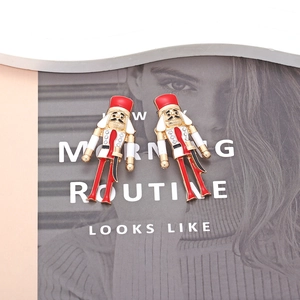 Detail of nutcracker soldier earrings with colorful enamel and crystal accents on magazine