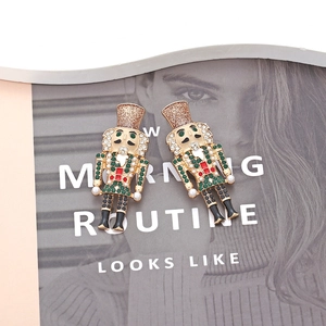 Nutcracker soldier earrings with colorful crystals and pearls on minimalist magazine background