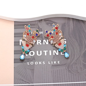 Sparkling Christmas reindeer earrings with pearls and colorful rhinestones on a magazine