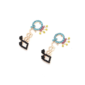 Détail de boucles d'oreilles Beer dorées avec strass colorés et motif couronne
