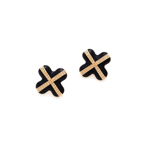 Detail of four-leaf clover earrings featuring black enamel and gold crisscross patterns