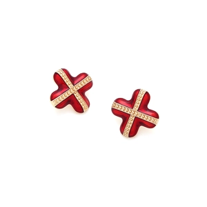 Detailed macro view of red enamel cross earrings with polished golden metallic borders