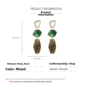Detail view of long geometric resin drop earrings with marble textures and gold metal frame