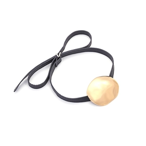 Minimalist black leather necklace featuring a large irregular wavy gold metal pendant