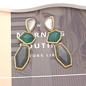 Detail of three-tier geometric drop earrings with gold bead edges and colorful resin