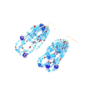 Detail of blue and white beaded tassel earrings with bohemian floral patterned beads
