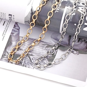 Mehrlagige gold- und silberne Gliederkette mit ovalem Design auf einem Modemagazin