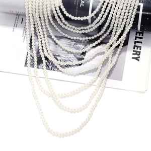 Macro shot of multi-layer pearl waterfall necklace with glossy white layered beads