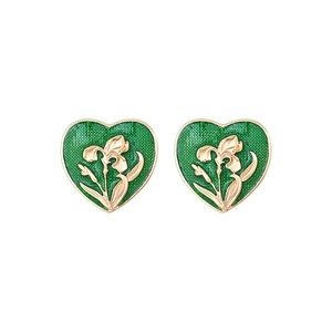 Detail view of heart earrings with green enamel and gold iris floral relief pattern