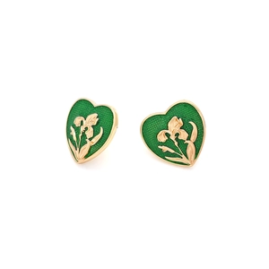 Detailed macro view of vintage gold heart earrings with green enamel and iris flower relief
