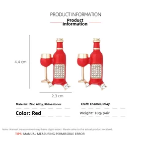 Detailed view of red enamel wine bottle and glass earrings with crystal rhinestones