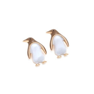 Close-up of penguin earrings with brown and white enamel on a gold alloy base