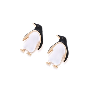 Detailed close-up of cute penguin earrings with black and white enamel and gold plating