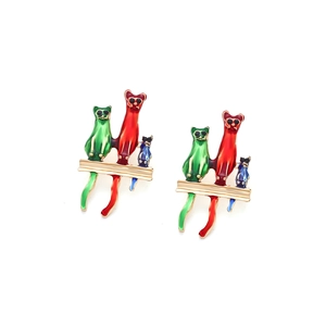 Detalle de pendientes de gato en esmalte de colores con acabado dorado y pedrería