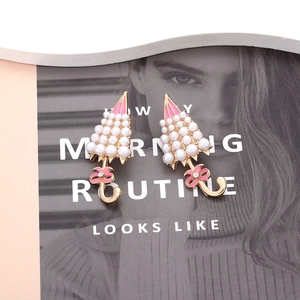 Pink enamel umbrella earrings with pearls and bowknots on a fashion magazine backdrop