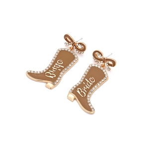 Makroaufnahme von Cowboy-Stiefel-Ohrringen mit Glitzersteinen und dem Aufdruck Bride