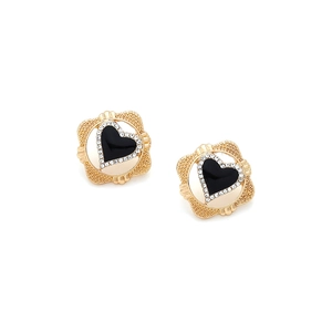 Detail of vintage heart earrings with gold frame, black center, and tiny white crystals