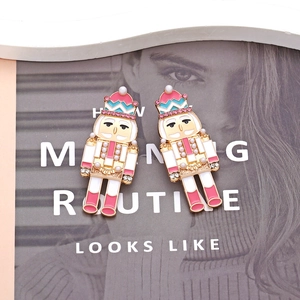 Boucles d'oreilles Casse-noisette en émail rose, perles et cristaux sur fond de magazine