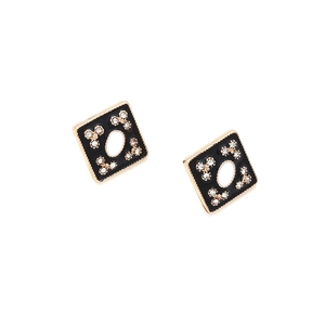 Detailed macro view of retro geometric gold studs with black enamel and crystal inlay
