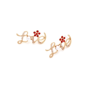 Detail view of gold Love letter earrings with pearl and red rhinestone flower stud