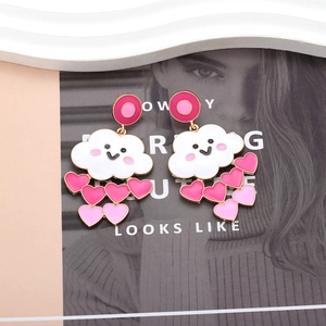 Detail showing white cloud earrings with smiling faces and pink heart-shaped charms