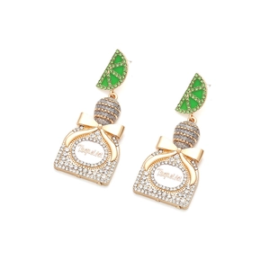 Macro detail of Tequila bottle earrings with gold bow and pavé crystal lime accents