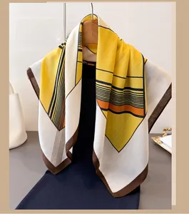 Close-up of geometric color block scarf in yellow and brown on a wooden hanger