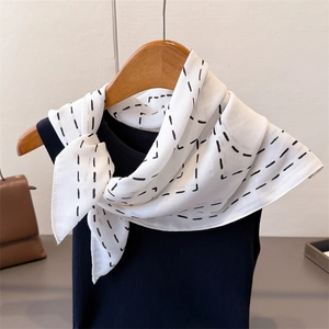 Elegant geometric herringbone linen silk scarf styled on a chic black vest