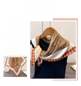 Detailed pattern of brown leaf veins and houndstooth texture on a silk-like square scarf