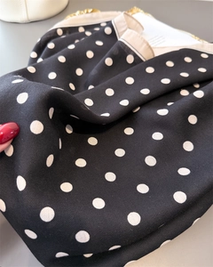 Close-up of black and white polka dot scarf with fine twill texture and soft drape