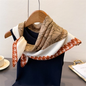 Palm leaf print silk scarf with brown houndstooth border styled on a navy vest