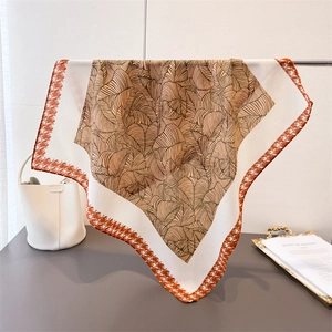 Silk-like square scarf featuring brown leaf patterns and herringbone border detail